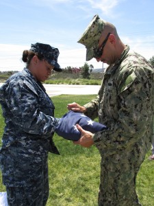 Petty Officer Second Class Kim Gieseking, of Navy Medical Center, San Diego, and Petty Officer First Class Jose Ruiz, of Seal Team 5, carefully fold a flag that had been flown on the Avenue of Flags since Nov. 1, 2013.  