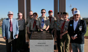 Outpost Harry veterans Bob Baker, left, and John Lody, far right, with San Diego Boy Scouts at a memorial plaque for Korean War veterans. The plaque is placed at the base of the Veterans Tribute Tower & Carillon.